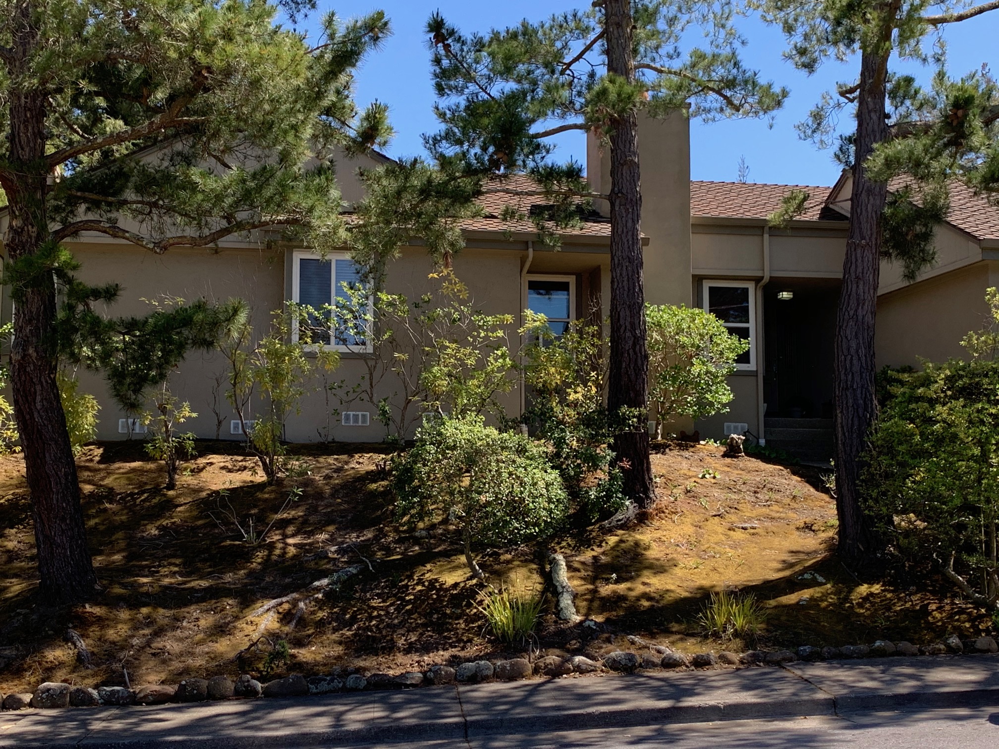 a house with a yard and trees in front of it